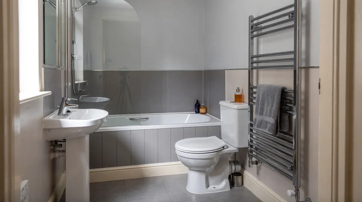 Newly refurbished bathroom with a white suite and chrome towel rail
