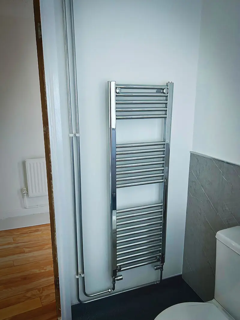 Newly fitted chrome towel radiator in a refurbished bathroom