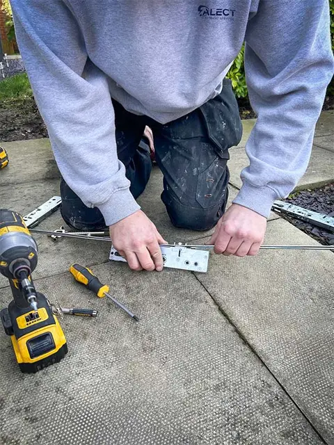 Engineer repairing a multi-point locking mechanism on a front door